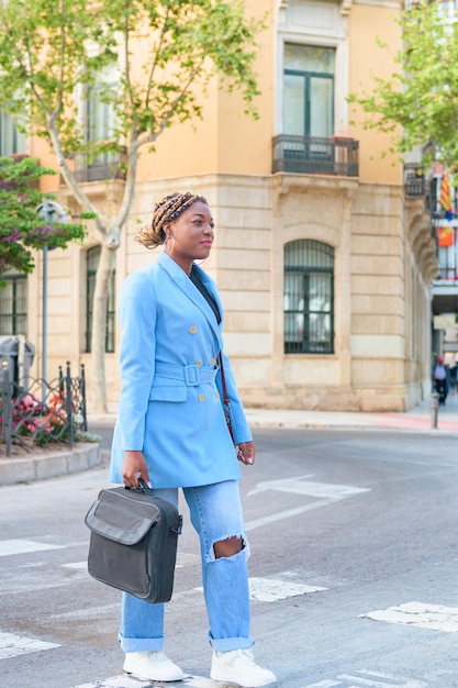 Photo femme d'affaires noire avec un costume bleu traverser la rue