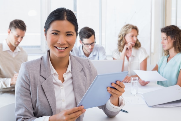 Femme d&#39;affaires occasionnel à l&#39;aide de sa tablette lors d&#39;une réunion