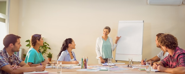 Femme d&#39;affaires occasionnel donnant une présentation à ses collègues