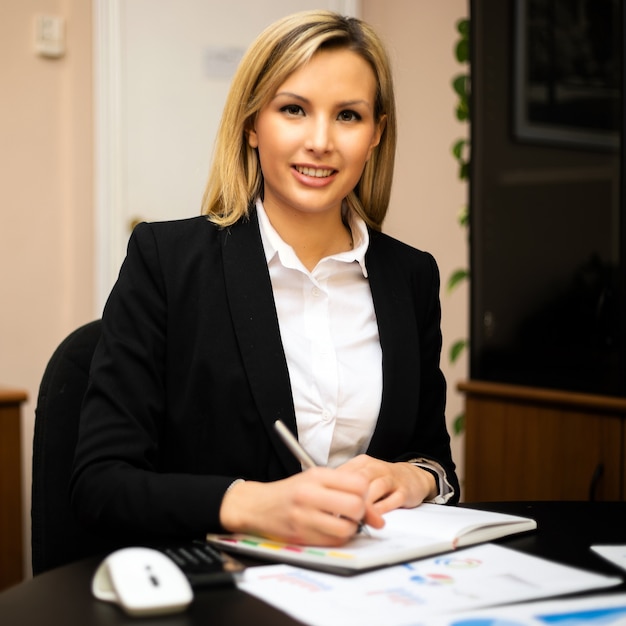 Photo femme d'affaires occupée écrivant dans un ordre du jour sur un ordinateur de bureau au bureau