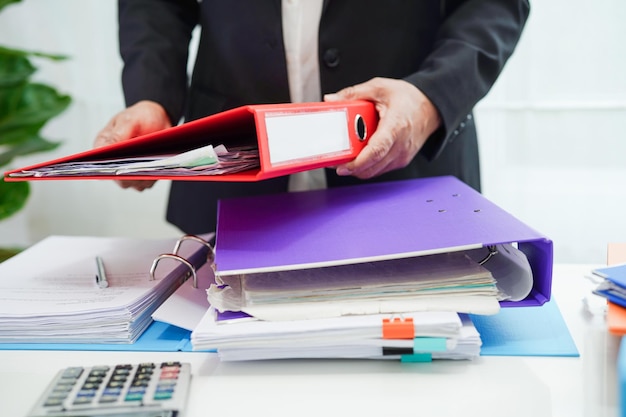 Femme d'affaires occupée à travailler avec des documents au bureau