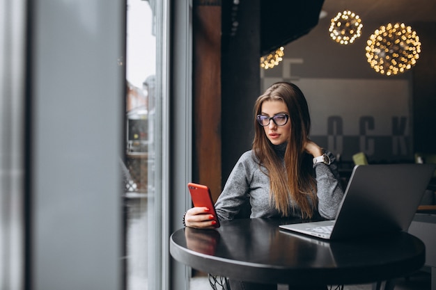 Femme d&#39;affaires avec ordinateur portable dans un café