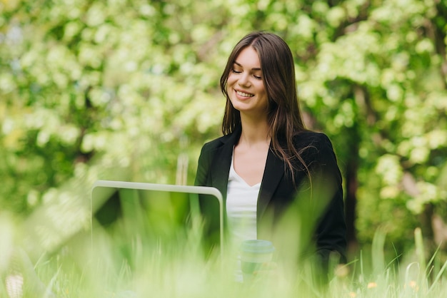 Femme d'affaires avec ordinateur portable dans le parc