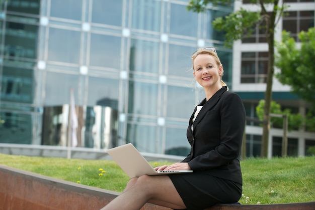 Femme d&#39;affaires avec un ordinateur portable à l&#39;extérieur