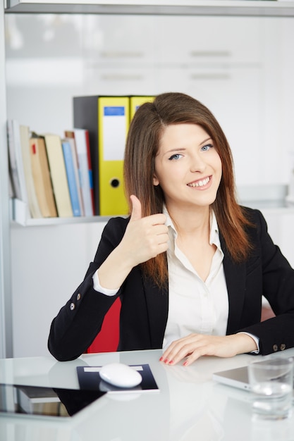 Femme d'affaires parlant au mobile et travaillant au bureau avec ordinateur portable