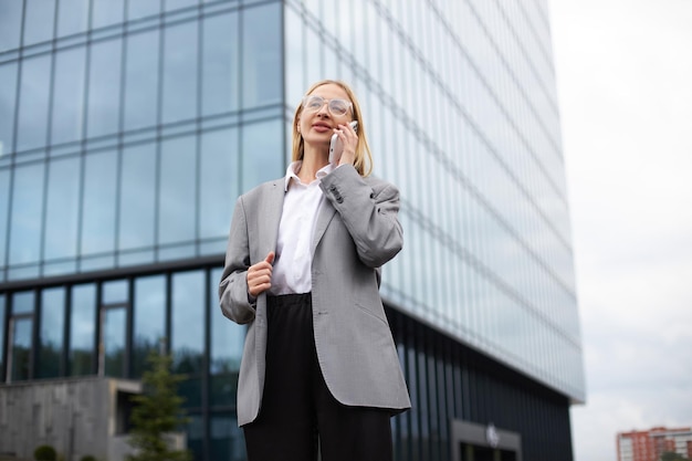 Femme d'affaires parlant au téléphone portable se tenant sur le concept de technologie de rue