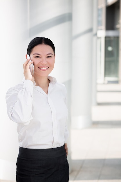 Femme d'affaires parlant au téléphone et souriant.