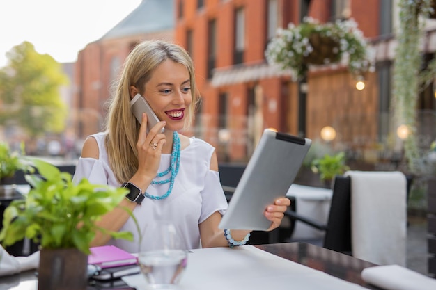 Femme d'affaires parlant au téléphone et utilisant une tablette