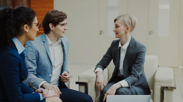 Femme d'affaires parlant et discutant de l'avenir avec des partenaires commerciaux dans un centre de bureaux moderne