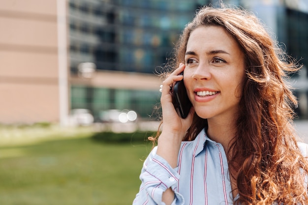 Femme d'affaires parlant sur un téléphone portable dans le centre-ville, portrait en gros plan