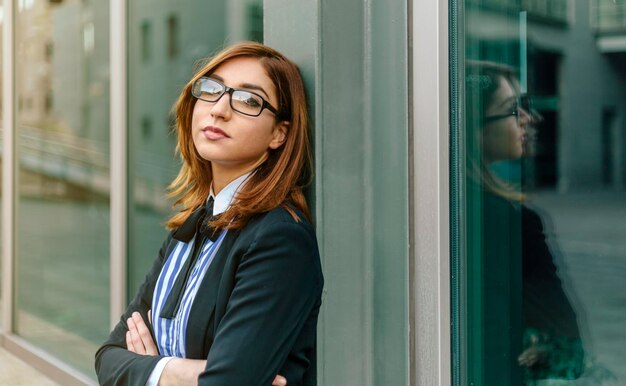 femme affaires, pencher, fenêtre, à, bras croisés