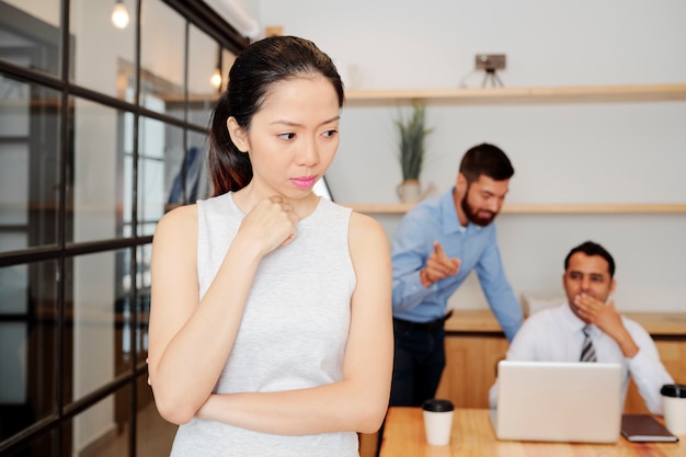 Femme d'affaires pensive debout au bureau