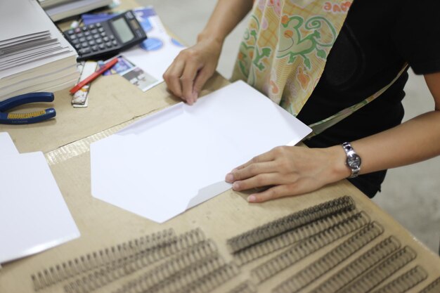 Photo une femme d'affaires plie du papier à son bureau.