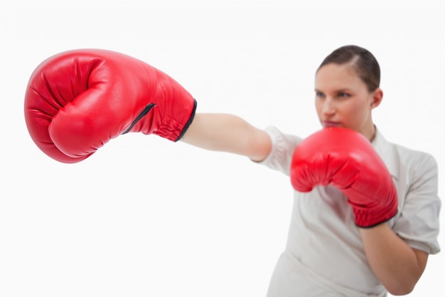 Femme d&#39;affaires poinçonnage quelque chose avec des gants de boxe