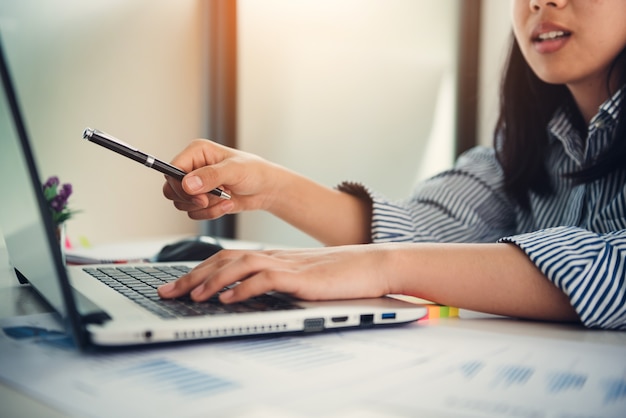 Femme d&#39;affaires pointant l&#39;écran avec un stylo.