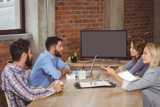 Femme d&#39;affaires pointant vers des collègues masculins au bureau