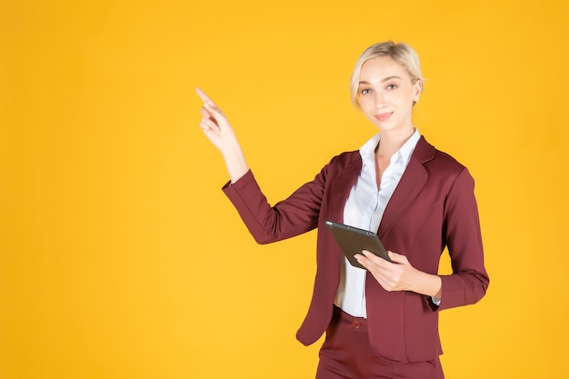 Femme d'affaires pointe quelque chose sur fond jaune