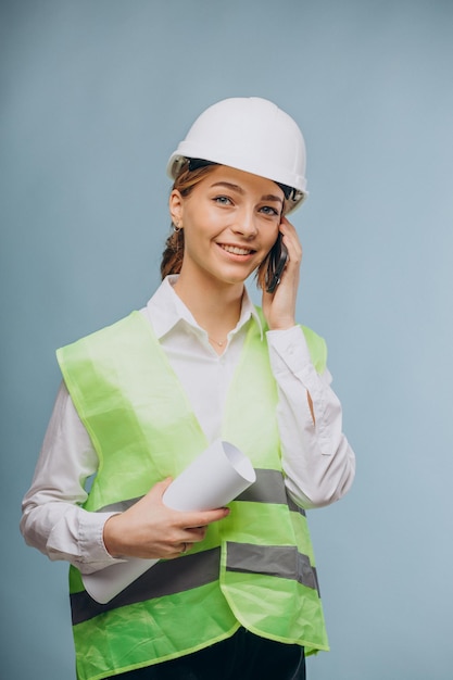 Femme d'affaires portant un gilet et un casque parlant au téléphone