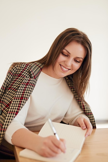 Femme d'affaires prenant des notes dans le planificateur au bureau