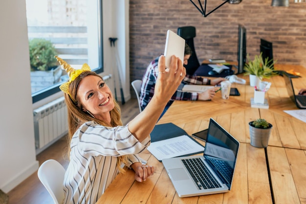 Photo femme d'affaires prenant le selfie avec le bandeau de licorne