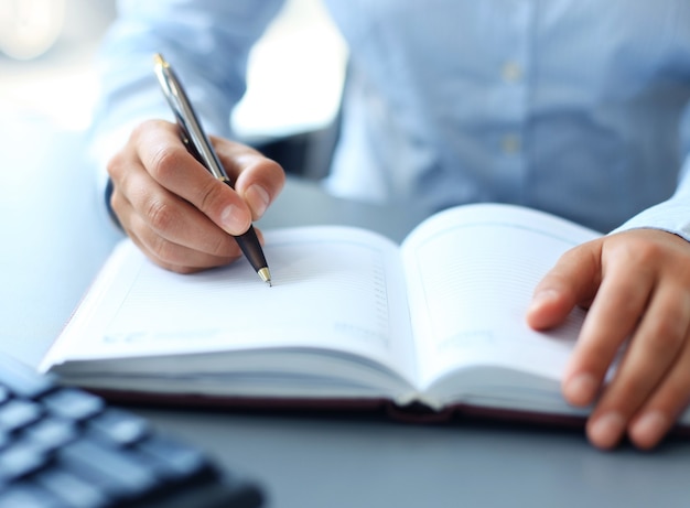 La femme d'affaires prend une note dans le cahier.