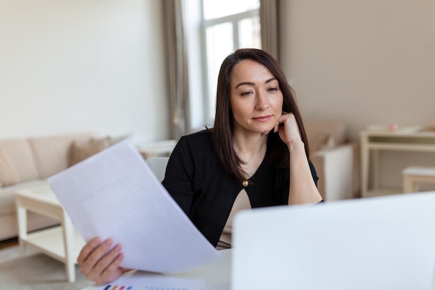 Femme d'affaires présentant des tableaux et des graphiques lors d'un appel vidéo en ligne Femme d'affaires d'âge moyen ayant une conférence téléphonique avec un client sur un ordinateur portable