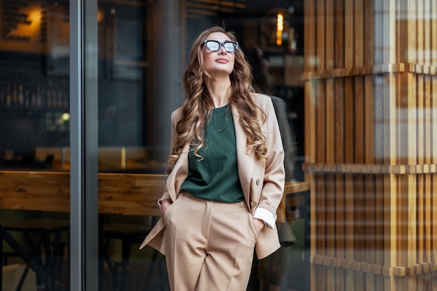Femme d'affaires propriétaire de restaurant habillé élégant Pantsuit debout près du restaurant grande fenêtre en plein air caucasien femme lunettes femme d'affaires