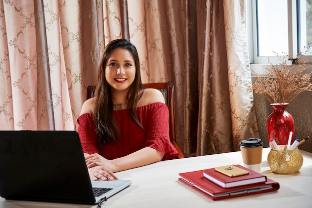 Femme d'affaires prospère travaillant à la table au bureau