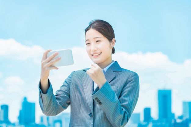 Une femme d'affaires qui regarde avec enthousiasme l'écran d'un smartphone