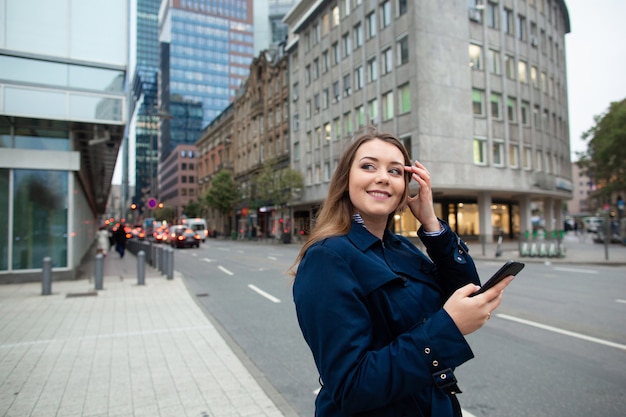 Femme d'affaires à la recherche d'un emplacement dans le téléphone, pour une réunion d'affaires. Photo demi-longueur.