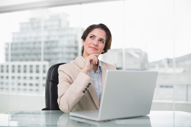 Femme d&#39;affaires réfléchie à l&#39;aide d&#39;ordinateur portable à son bureau