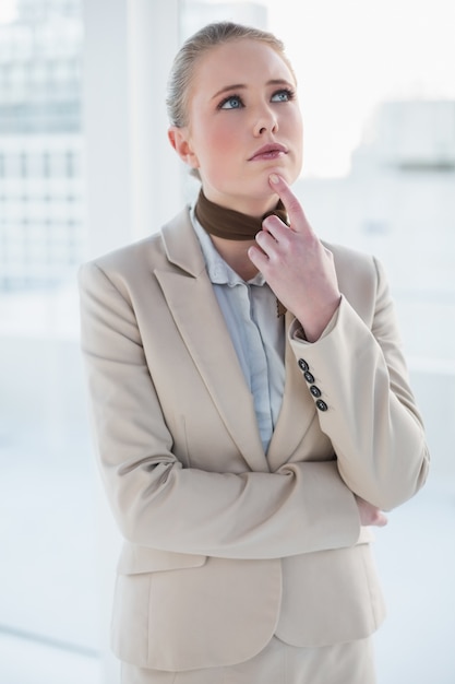 Femme d&#39;affaires réfléchie blonde en levant