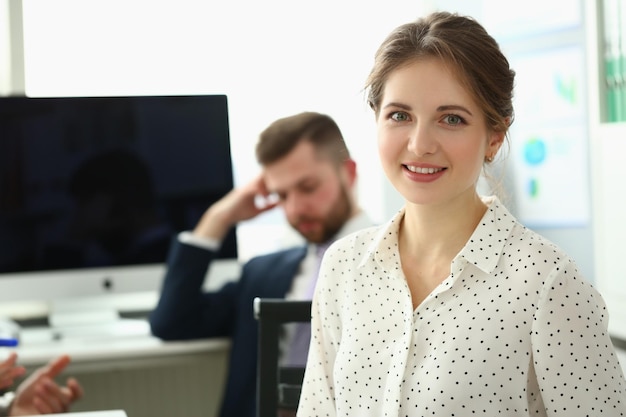 Femme d'affaires avec un regard positif et un sourire joyeux pose pour la caméra