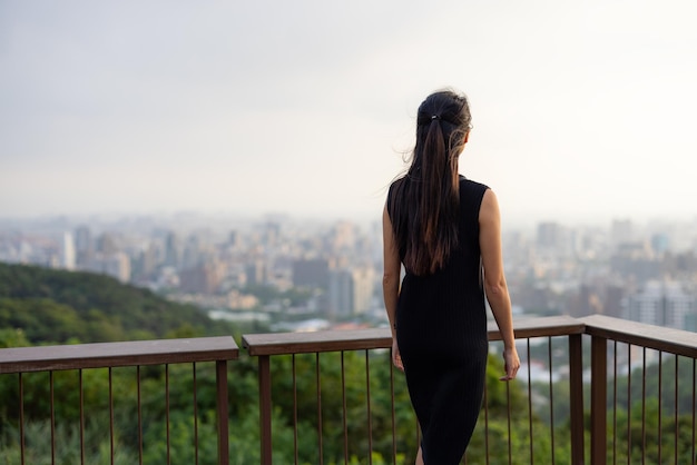 Femme d'affaires regarde la ville sur la montagne