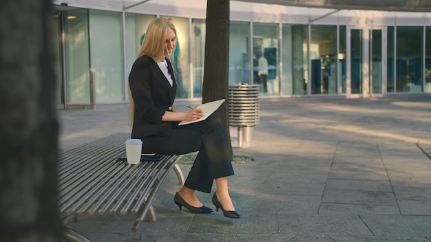 Femme d'affaires réussie, prendre des notes à l'extérieur.