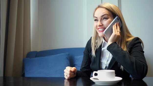 Femme d'affaires réussie utilisant le téléphone intelligent