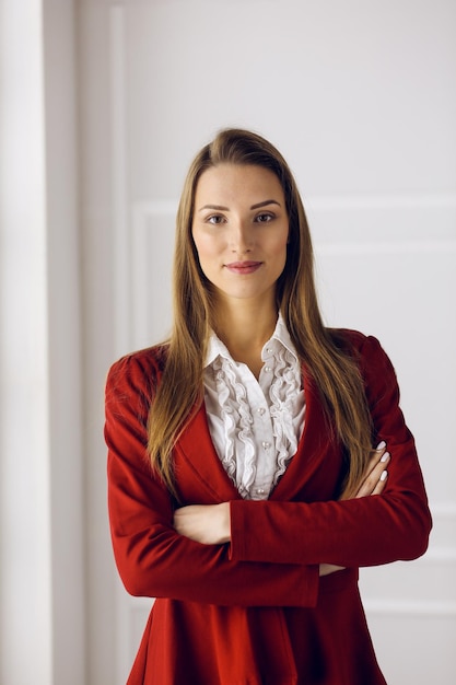 Femme d'affaires en rouge debout au bureau moderne. Portrait d'une jeune femme entrepreneure.