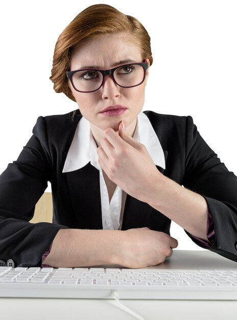 Femme d&#39;affaires rousse de pensée assis au clavier