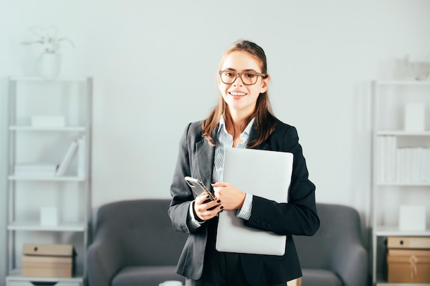 Femme d'affaires s'asseoir à l'intérieur du bureau à l'aide d'un ordinateur portable au bureau