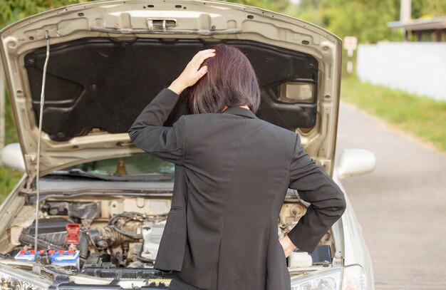 Femme d'affaires avec sa voiture cassée.