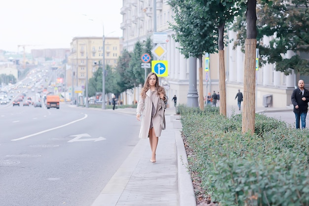 femme d'affaires se dresse sur la route, les voitures, la circulation, le style urbain, les voyages dans la ville, la femme et les voitures