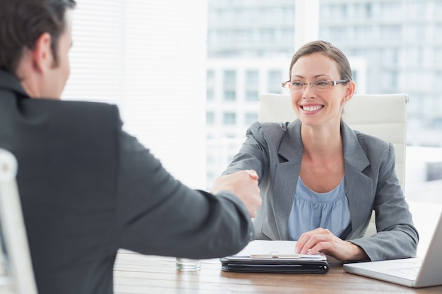 Femme d&#39;affaires se serrant la main avec un homme d&#39;affaires