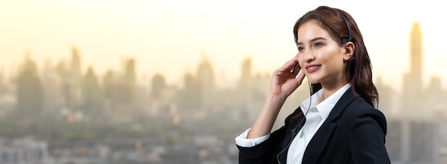 une femme d'affaires séduisante et des casques sourient en travaillant. assistant de service client travaillant