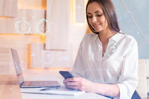 Femme d'affaires séduisante en chemise blanche utilisant un téléphone intelligent pour optimiser le développement en impliquant de nouvelles technologies dans les processus commerciaux Hologramme de haute technologie sur fond de bureau moderne