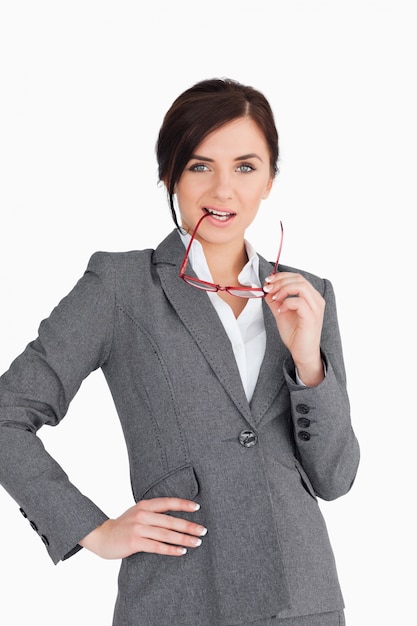 Femme d&#39;affaires séduisante mettant ses lunettes dans sa bouche