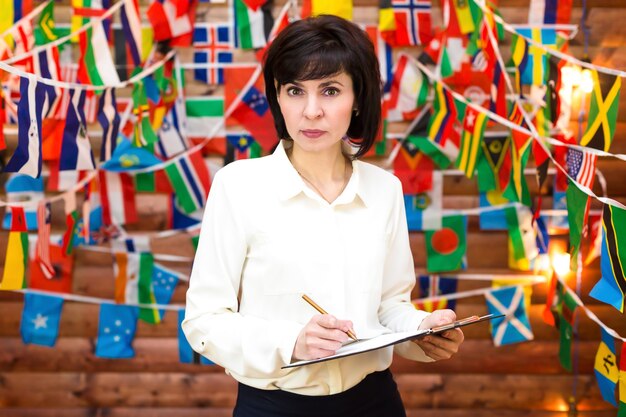 Une Femme D'affaires Sérieuse A Froncé Les Sourcils Sur Le Fond D'un Mur De Drapeaux.