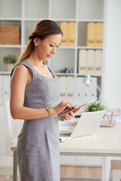 Femme d'affaires sérieuse avec tablette au bureau