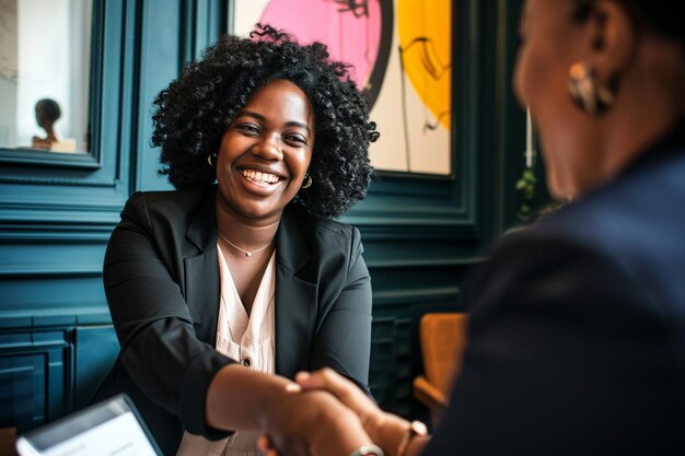 Une femme d'affaires serre la main d'un employé lors d'une réunion de travail.