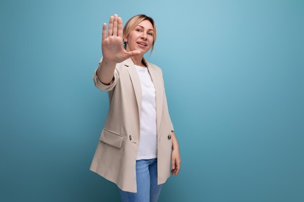 Femme d'affaires soignée et soignée dans une veste beige sur fond de studio