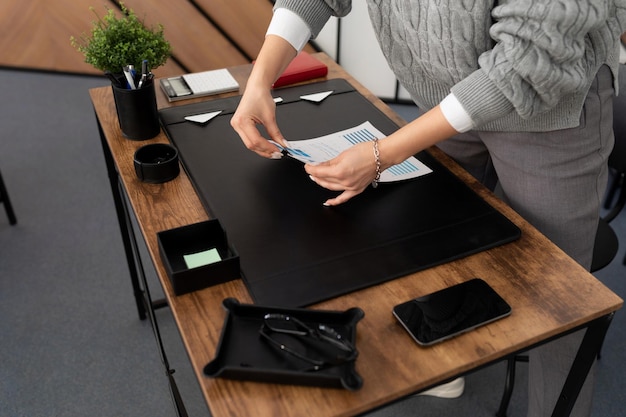 Une femme d'affaires à son bureau au bureau plie une pile de documents